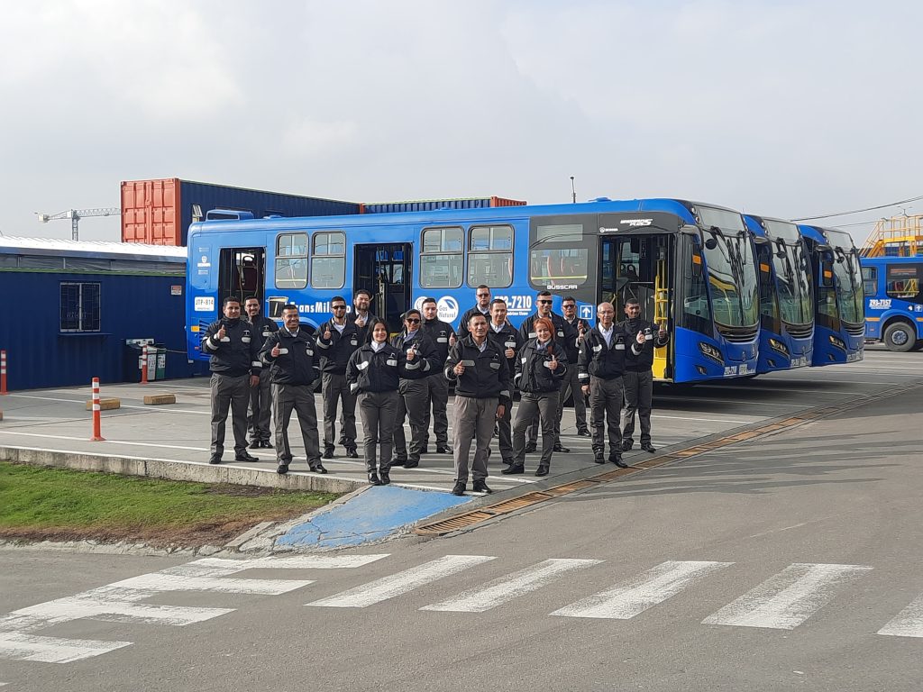 operadores posando frente a buses del concesionario